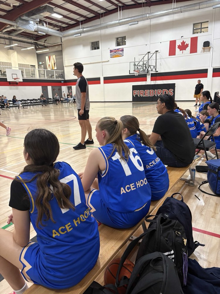 ACE Hoops players watching from the bench at a tournament